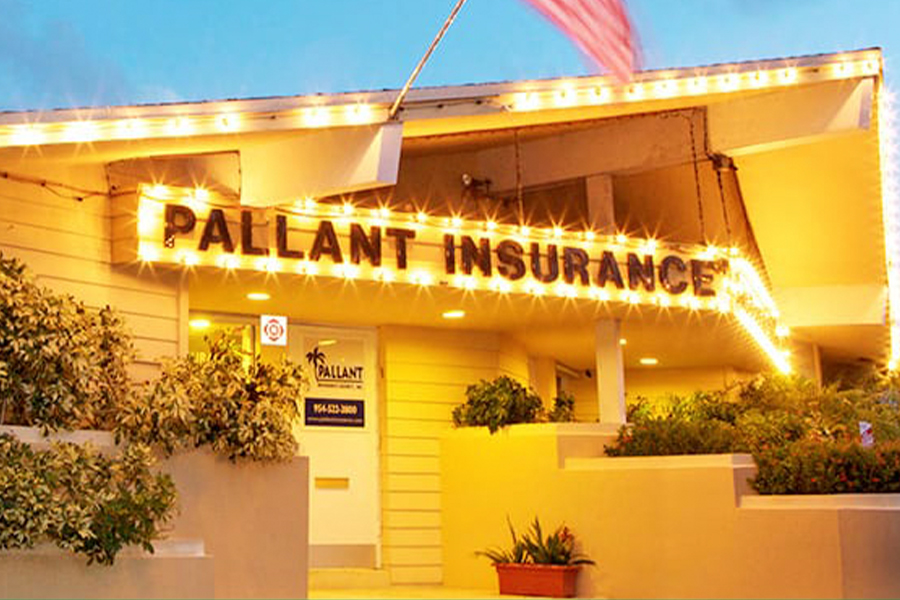 Fort Lauderdale, FL - Closeup View of Pallant Insurance Agency Office Building at Night with String Lights and American Flag
